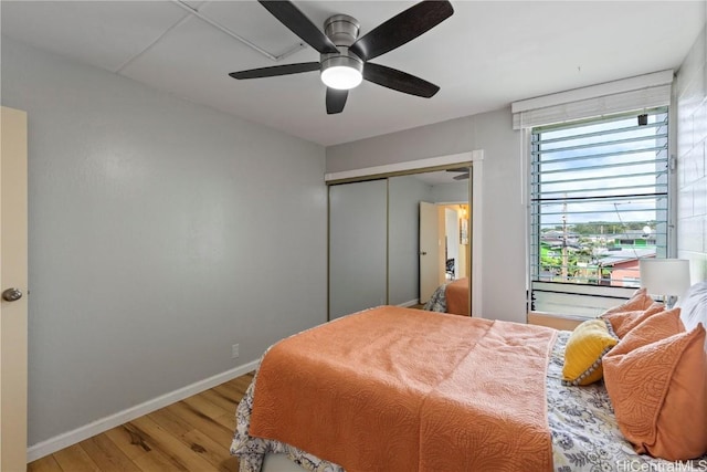 bedroom with wood-type flooring, a closet, and ceiling fan