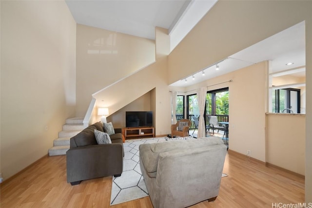 living room with light hardwood / wood-style floors and rail lighting