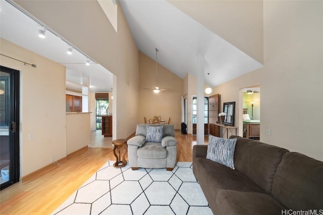 living room with light hardwood / wood-style floors, vaulted ceiling, and ceiling fan