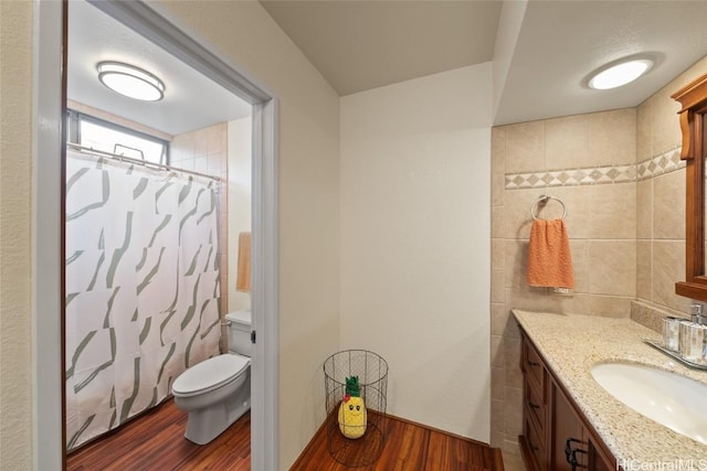 bathroom featuring a shower with curtain, hardwood / wood-style flooring, vanity, and toilet