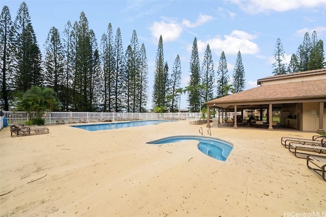 view of swimming pool with a hot tub and a patio area