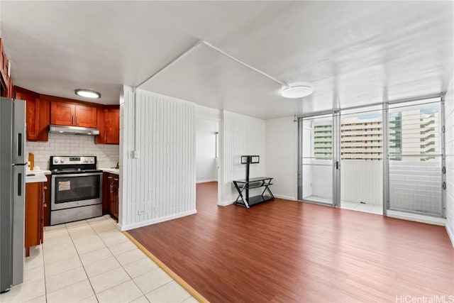 kitchen with tasteful backsplash, light tile patterned floors, and appliances with stainless steel finishes