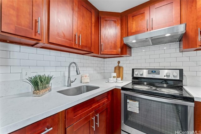 kitchen with light stone counters, electric stove, sink, and tasteful backsplash