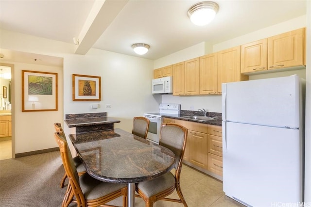 kitchen featuring light brown cabinets, beamed ceiling, white appliances, and sink