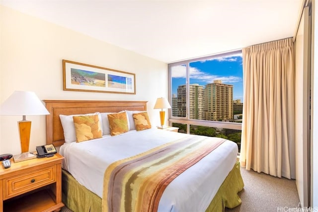 bedroom featuring expansive windows and light colored carpet