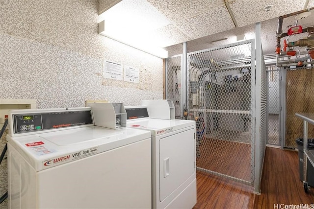 laundry area with washer and dryer and dark hardwood / wood-style floors