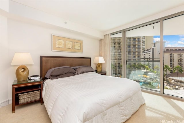 carpeted bedroom featuring a wall of windows and access to outside