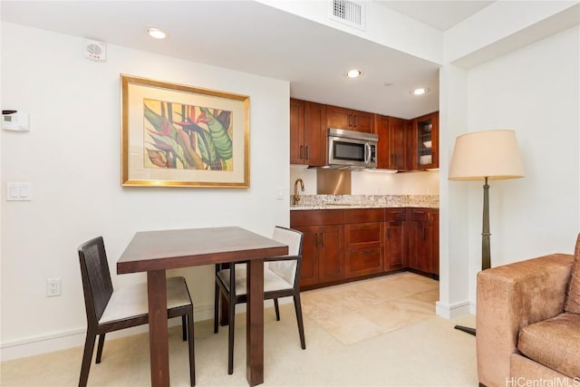 kitchen featuring light stone counters and sink