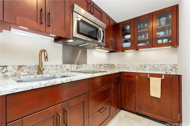 kitchen featuring light stone countertops, sink, and light tile patterned floors