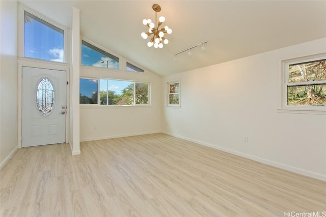 entrance foyer featuring a notable chandelier, light hardwood / wood-style floors, high vaulted ceiling, and track lighting