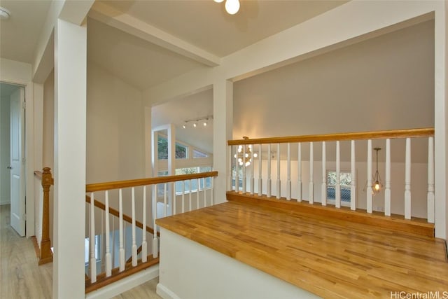 hall featuring vaulted ceiling with beams, light hardwood / wood-style flooring, and an inviting chandelier