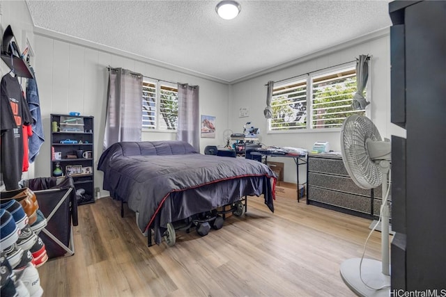 bedroom with a textured ceiling and hardwood / wood-style flooring