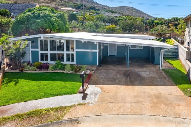 view of front of home featuring a mountain view, a front lawn, and a carport