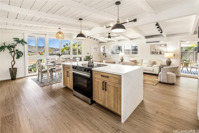 kitchen featuring beam ceiling, light hardwood / wood-style floors, pendant lighting, and range