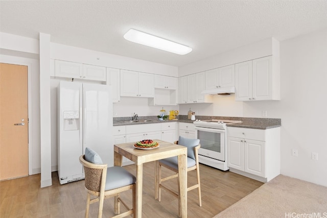 kitchen featuring white cabinetry, sink, hardwood / wood-style floors, and white appliances