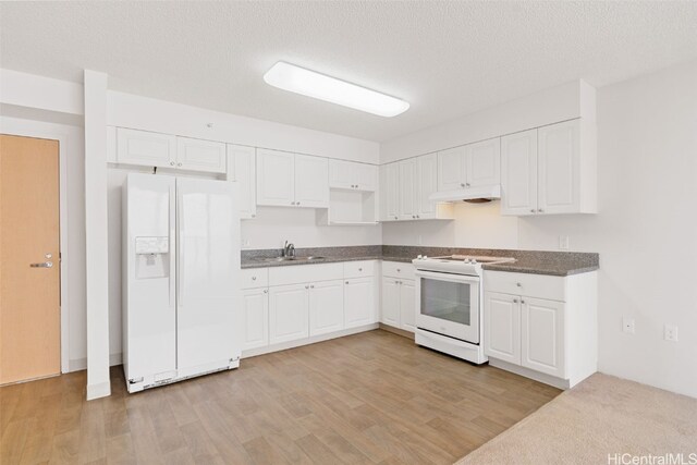 kitchen with white cabinets, a textured ceiling, white appliances, and light hardwood / wood-style flooring