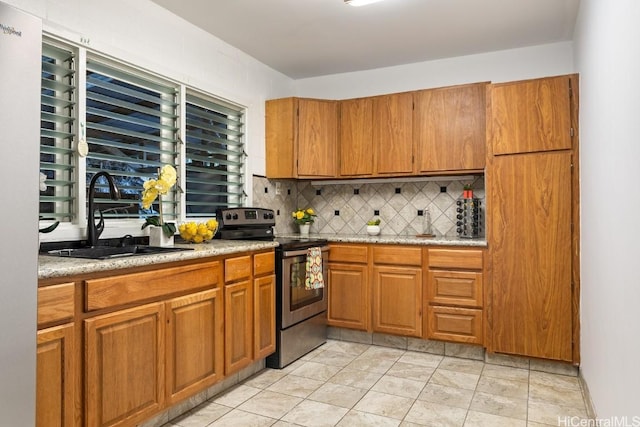 kitchen with tasteful backsplash, sink, and stainless steel range with electric cooktop