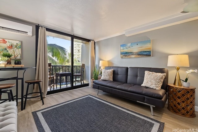 living room featuring crown molding, light hardwood / wood-style floors, expansive windows, and a wall mounted AC