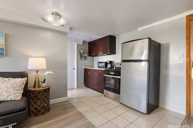 kitchen featuring stainless steel appliances, ornamental molding, light tile patterned floors, and dark brown cabinets