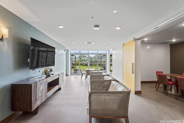 living area featuring visible vents, recessed lighting, a wall of windows, and baseboards