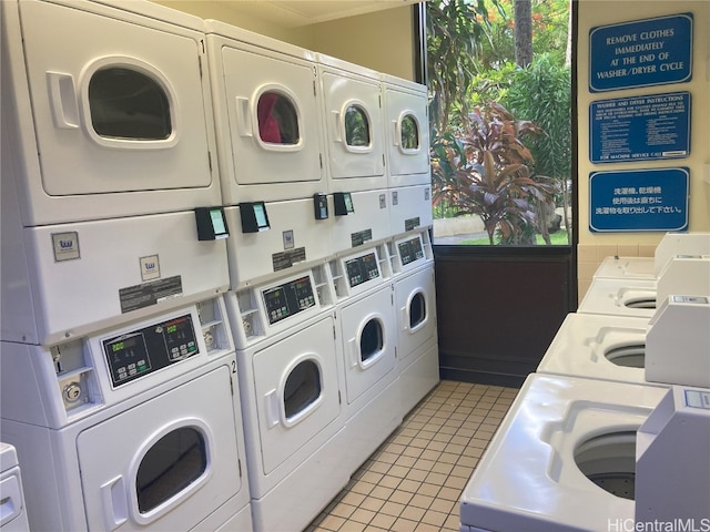 washroom with stacked washer / drying machine, light tile patterned floors, and washer and clothes dryer