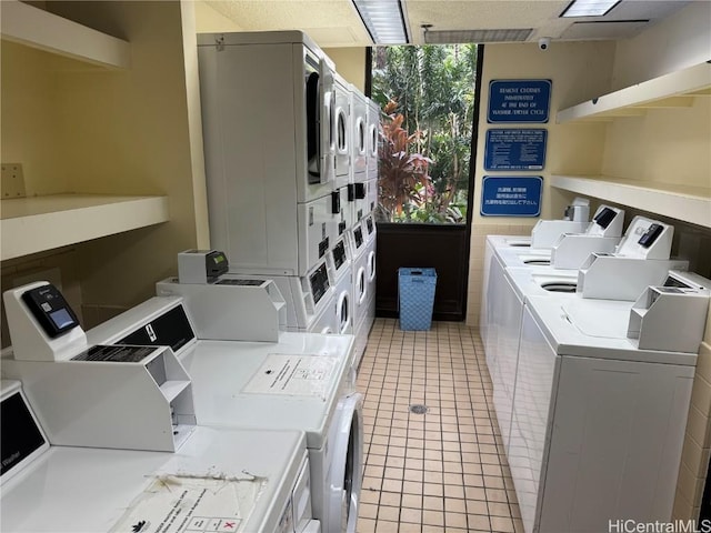 laundry room featuring stacked washer and clothes dryer, washing machine and dryer, and light tile patterned floors