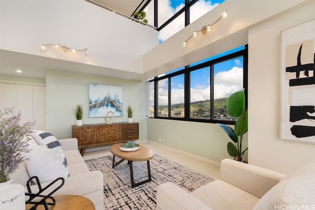 living area with a high ceiling and baseboards