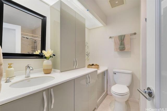 bathroom with tile patterned floors, vanity, toilet, and a tile shower