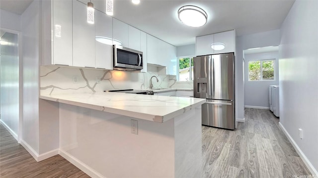 47-433 Hui Nene St, Kaneohe, HI 96744 - kitchen with stainless steel appliances, light wood finished floors, a peninsula, and a sink