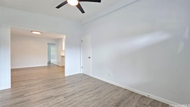 empty room with ceiling fan and light hardwood / wood-style flooring