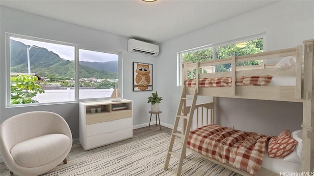 bedroom featuring a mountain view, an AC wall unit, and multiple windows