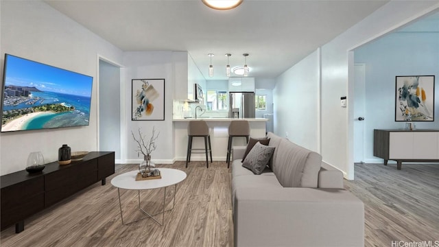 living room with light wood-type flooring and sink