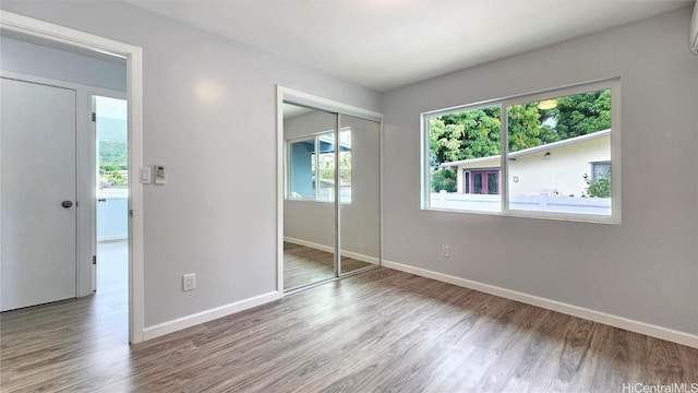 unfurnished bedroom with light hardwood / wood-style flooring and a closet