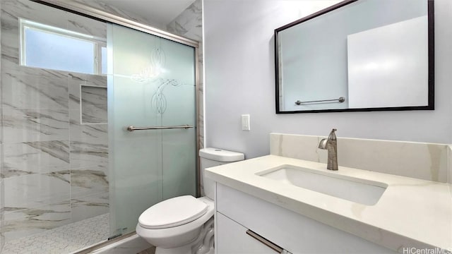 bathroom featuring vanity, a shower with shower door, and toilet