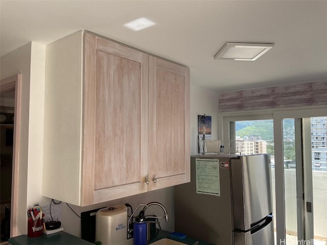 kitchen featuring stainless steel refrigerator and light brown cabinetry