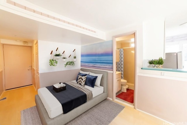 bedroom featuring light hardwood / wood-style flooring and ensuite bath