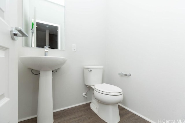 bathroom with hardwood / wood-style flooring and toilet