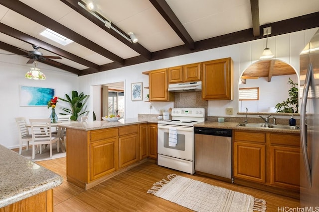 kitchen with sink, kitchen peninsula, a wealth of natural light, pendant lighting, and stainless steel appliances