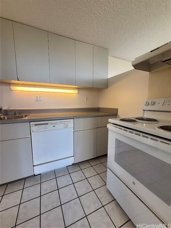 kitchen featuring sink, white cabinets, light tile patterned flooring, and white appliances