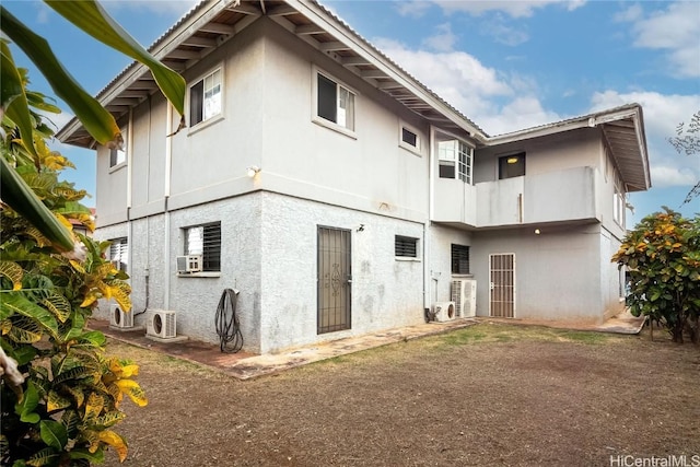 rear view of house featuring ac unit and cooling unit