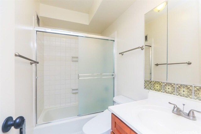 full bathroom featuring vanity, toilet, and bath / shower combo with glass door