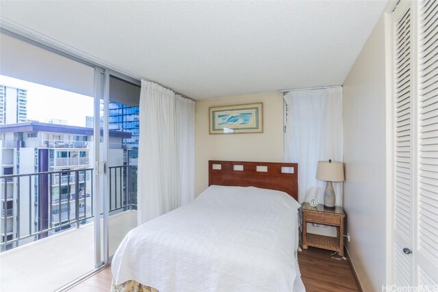 bedroom with hardwood / wood-style floors and a wall of windows