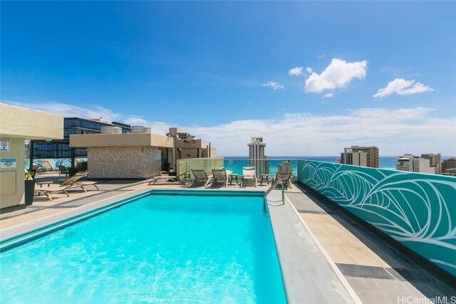 view of pool with a water view and a patio area