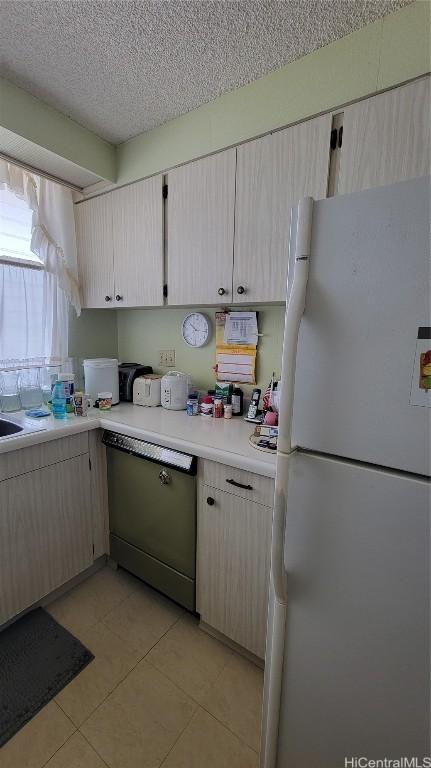 kitchen with dishwasher, a textured ceiling, and white refrigerator