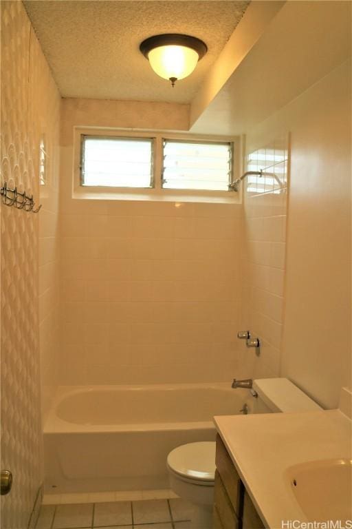 full bathroom featuring tile patterned flooring, vanity, tiled shower / bath combo, and toilet