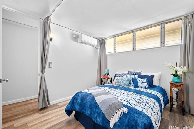 bedroom with hardwood / wood-style flooring and a wall mounted AC