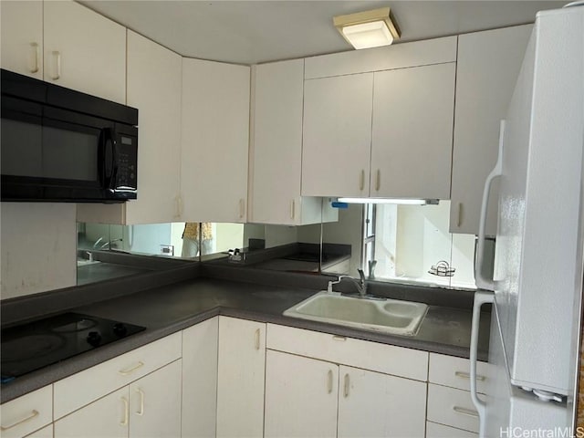 kitchen with white cabinetry, sink, and black appliances