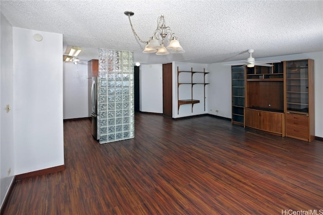 interior space with dark hardwood / wood-style floors, ceiling fan with notable chandelier, and a textured ceiling