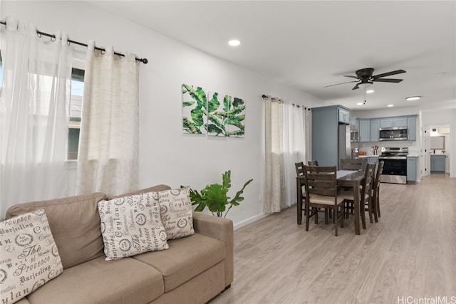 living room featuring ceiling fan and light wood-type flooring