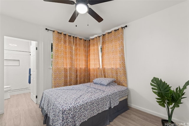 bedroom featuring connected bathroom, light hardwood / wood-style flooring, and ceiling fan